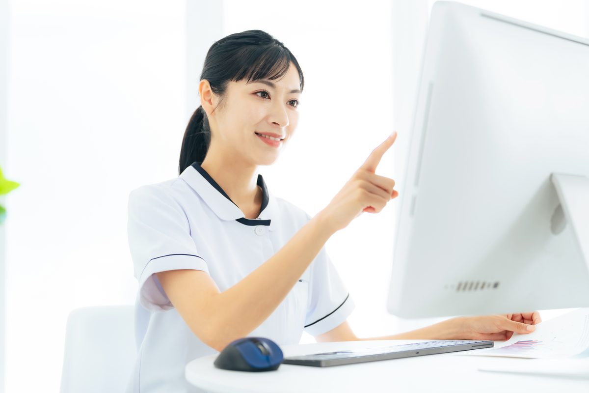受付で予約の確認をする医療事務