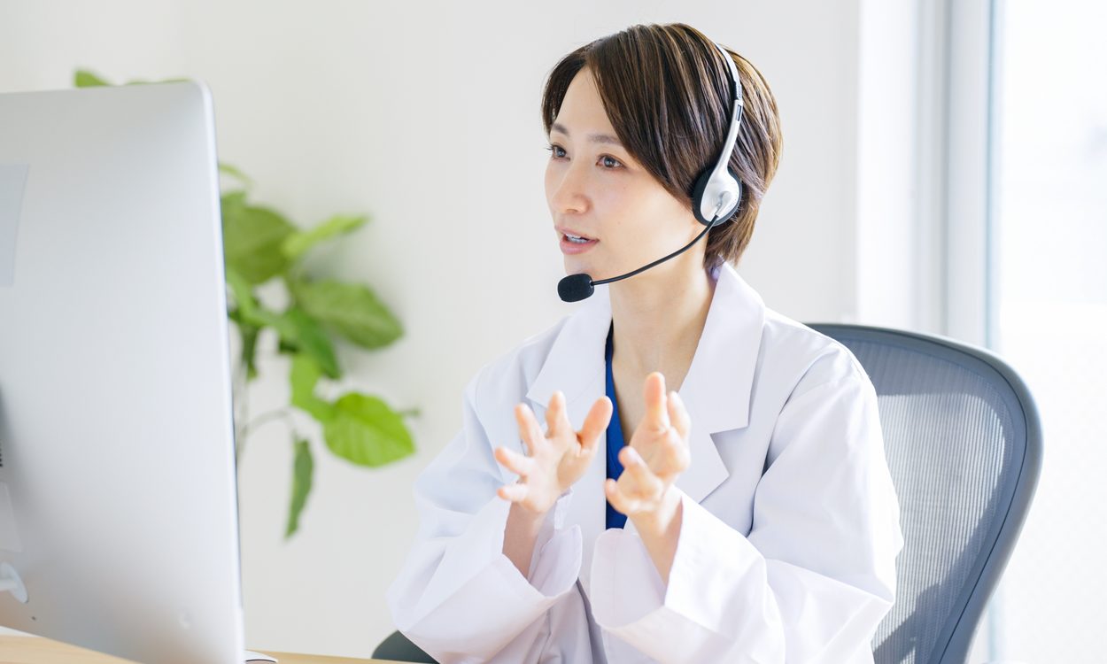 ヘッドセットをつけてオンライン診療をする医師